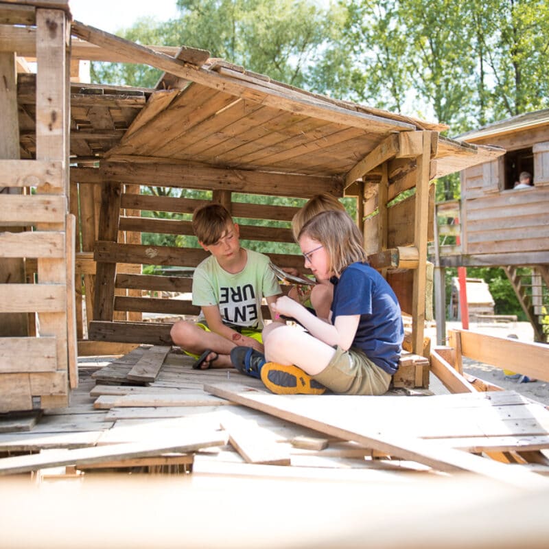 twee kinderen bouwen een hut
