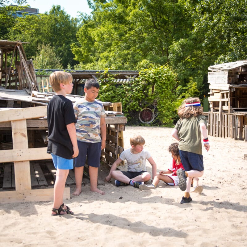 kinderen spelen in het huttenbouwdorp