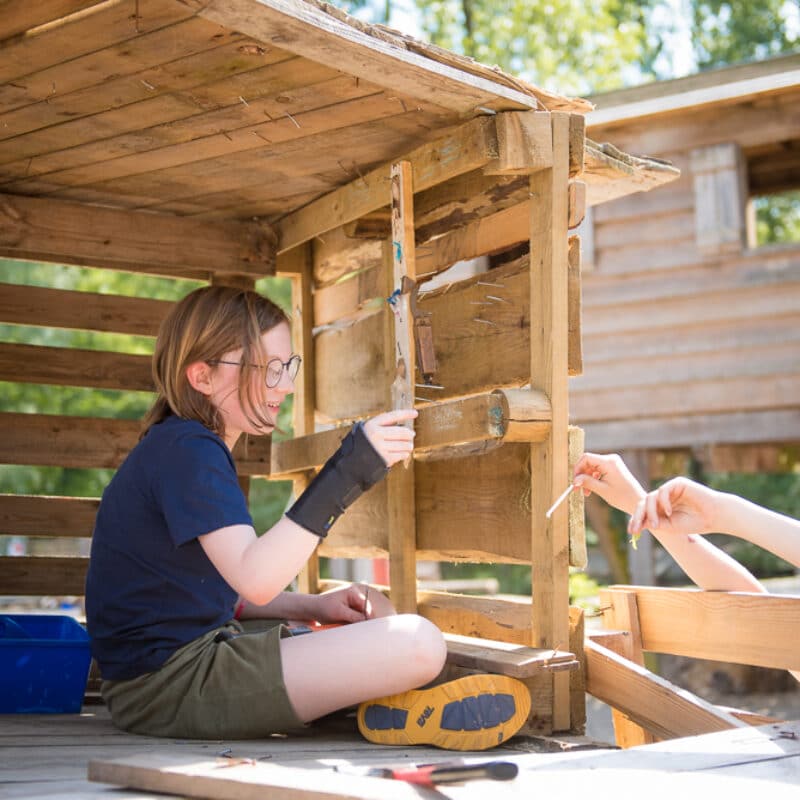 kind bouwt aan een hut