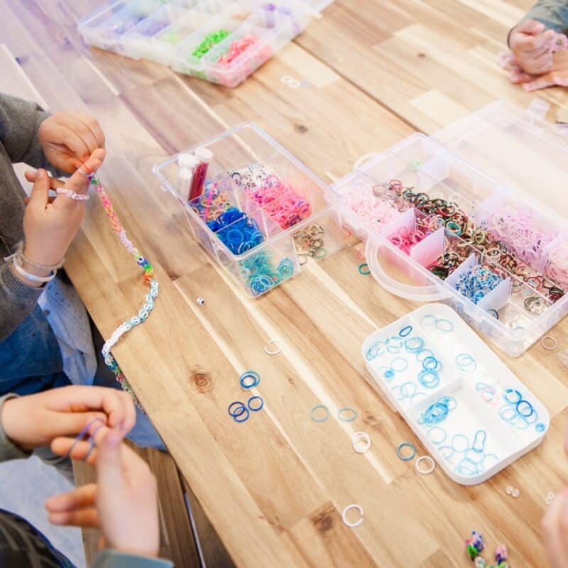 kinderen spelen aan tafel met elastiekjes op de buitenschoolse opvang